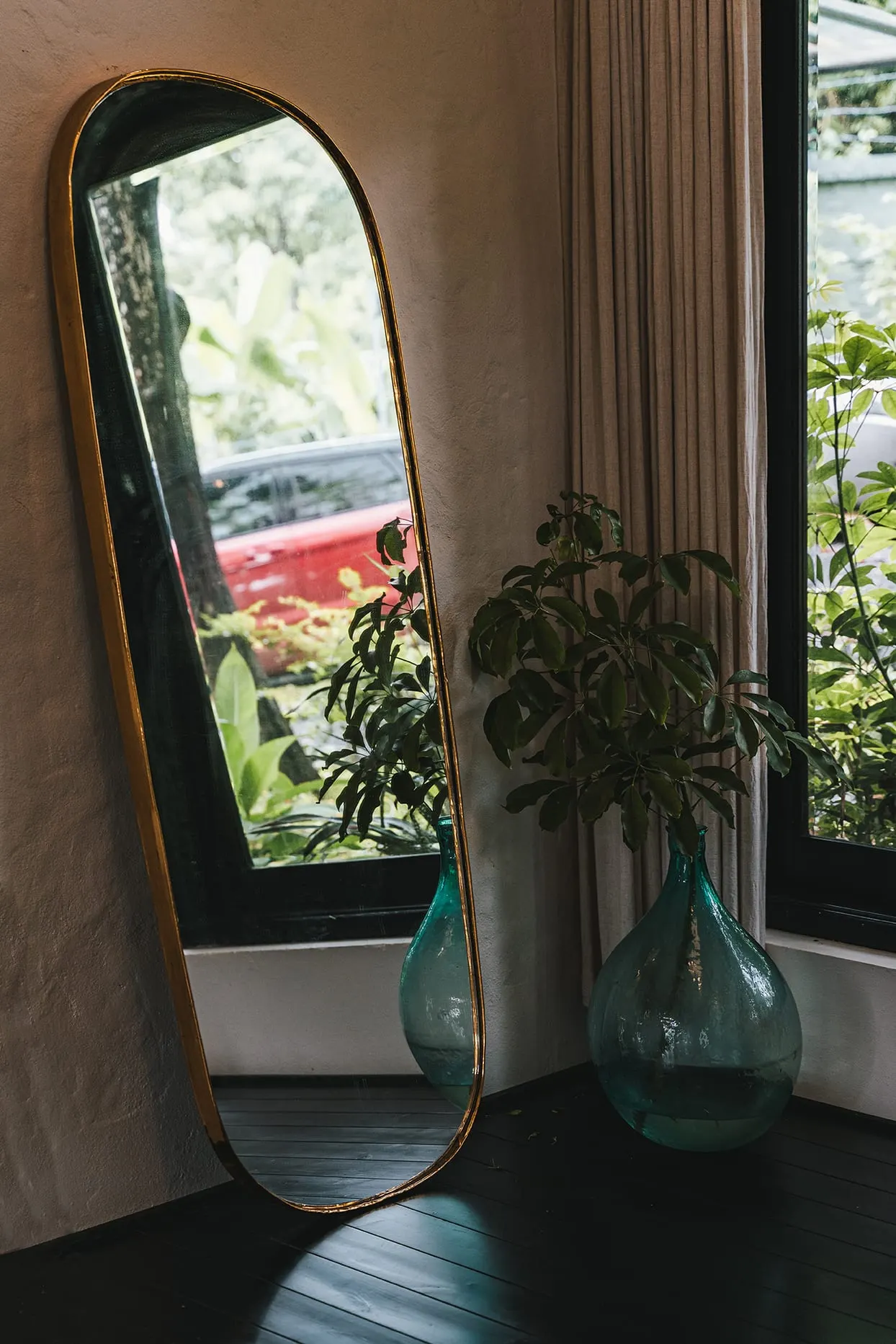 Gương soi và bình gốm bên khung cửa vườn